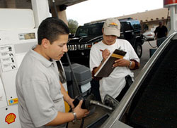 ニューメキシコ州サンタフェで車にガソリンを入れながら、有権者登録するアルフォンソ・マルチネス（© AP Images/Jeff Ceissler）