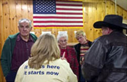 典型的な小さな町の党員集会で候補者について議論するアイオワ州民(© AP Images)