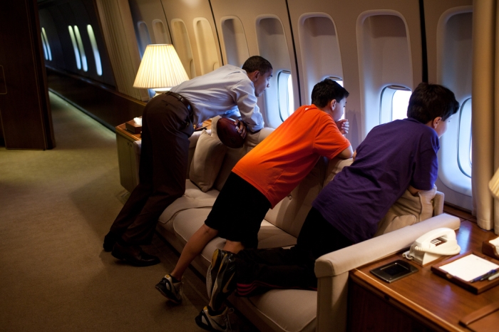 President Obama looks out a window of Air Force One with the sons of an aide during a flight to Hawaii in 2011. (White House)
