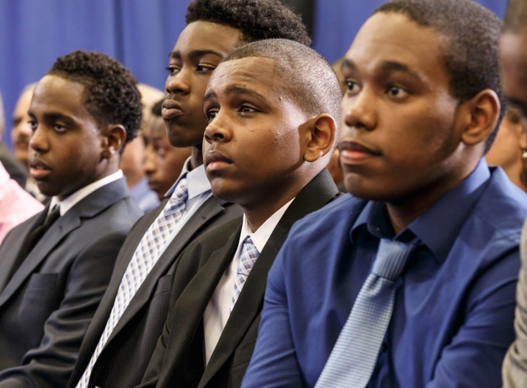 オバマ大統領の「マイ・ブラザーズ・キーパー」イニシアチブについてのスピーチに聞き入るアフリカ系アメリカ人の若者たち (© AP Images)