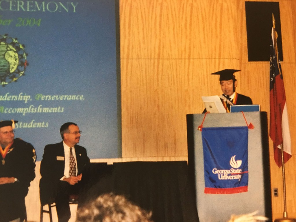 Suga delivering a speech at his graduation ceremony at Georgia State University.