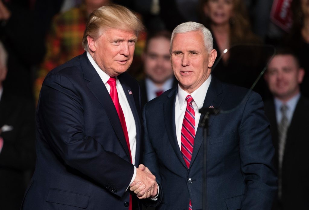 President Donald Trump, left, shakes hands with Vice President Mike Pence. (© AP Images)