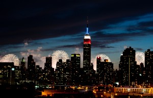 In New York, fireworks explode over the Hudson River behind the Empire State Building, lit red, white and blue for the Fourth of July. (Kathy Kmonicek/AP Images)