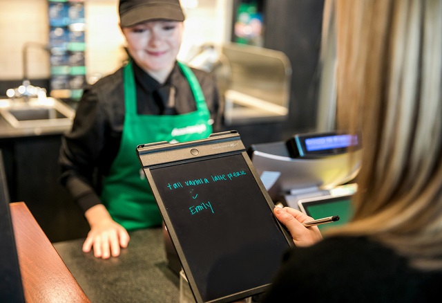 A customer makes an order at the Starbucks coffee chain’s first U.S. signing store in Washington. (© Joshua Trujillo/Starbucks)