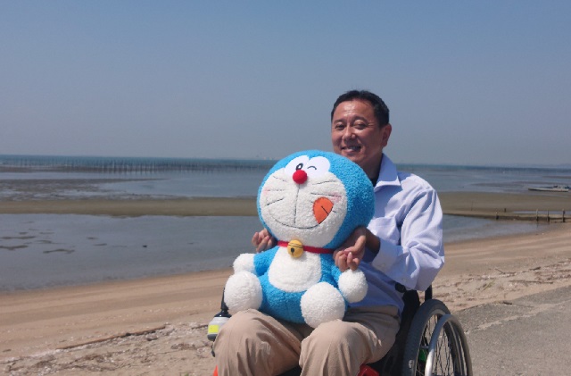 Tsuji holding "Doraemon."