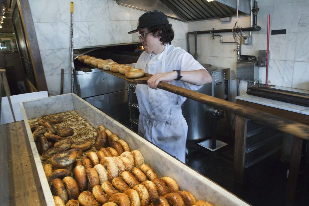 薪オーブンから焼きたてのベーグルを取り出す。ニューヨークのイーストビレッジにある「ブラック・シード・ベーグル」の店舗にて (AP Photo/Mary Altaffer)