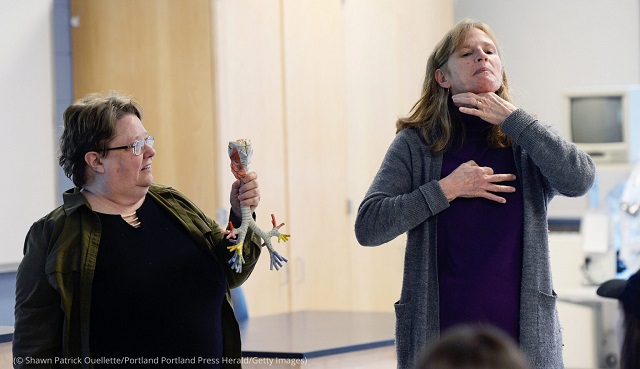 University of Southern Maine’s Judy Shepard-Kegl holds a model of trachea and bronchi as student Polly Lawson interprets during an American Sign Language medical class. (© Shawn Patrick Ouellette/Portland Portland Press Herald/Getty Images)