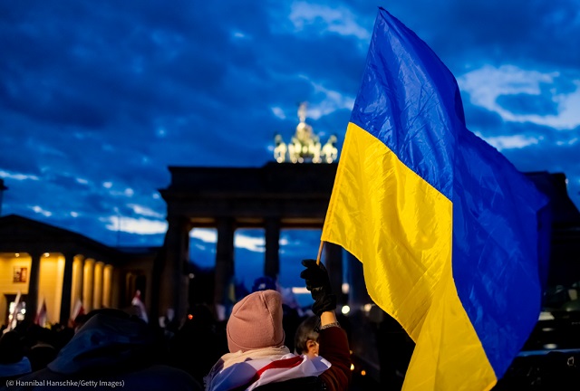 With the Brandenburg Gate illuminated in solidarity with Ukraine, people in Berlin gathered February 24 to oppose Russia's invasion. (© Hannibal Hanschke/Getty Images)