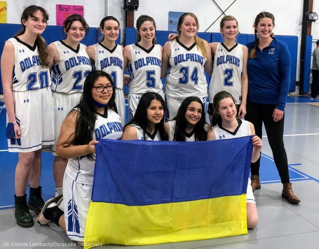 The Ocracoke Lady Dolphins show solidarity with Sonya Voitenko, a Ukrainian exchange student, front row right, after their final game February 24. (© Connie Leinbach/Ocracoke Observer)