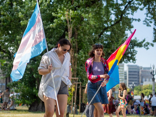 ポーランドのワルシャワで行われた「2021年平等のためのパレード」でトランスジェンダーの旗（左）とパンセクシャルの旗を掲げる参加者 (© Kornelia Kobiela/Shutterstock.com)