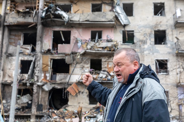 A man describes a Russian bombing of a residential building the day after the invasion began February 25. (© Mykhaylo Palinchak/SOPA Images/LightRocket/Getty Images)