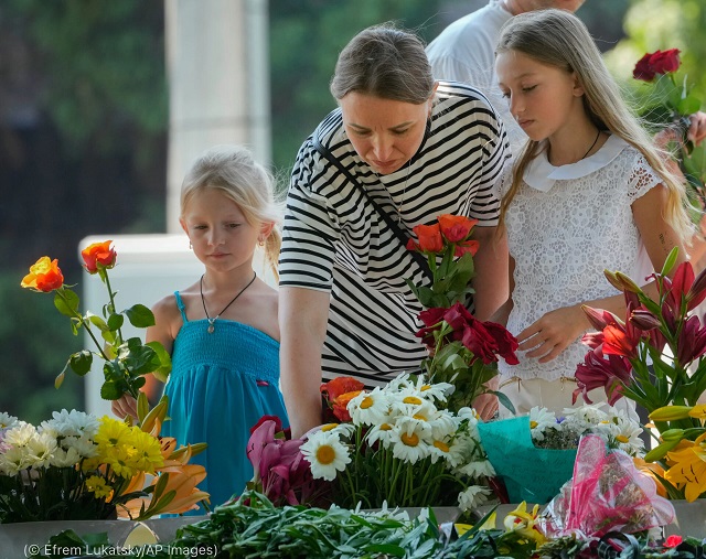People lay flowers June 29 to pay respect to victims of the Russian rocket attack on a shopping center in Kremenchuk, Ukraine. (© Efrem Lukatsky/AP Images)