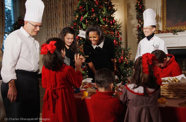 2011年、軍関係者の子どもたちと一緒にクッキーの飾り付けを行うミシェル・オバマ大統領夫人とホワイトハウスのパティシエ、ビル・ヨーゼス（左）(© Charles Dharapak/AP Images)
