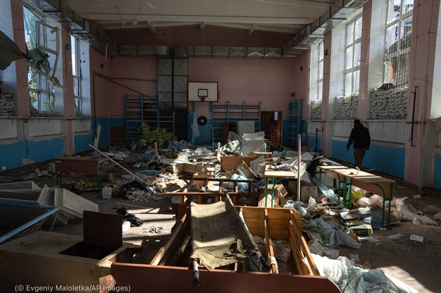 ロシア軍が軍の病院として使用していたイジュムにある学校体育館を歩く男性。AP通信の9月21日付の記事によると、記者たちは町にある拷問が行われた10カ所の場所を報道し、学校を含む5カ所を取材した (© Evgeniy Maloletka/AP Images)