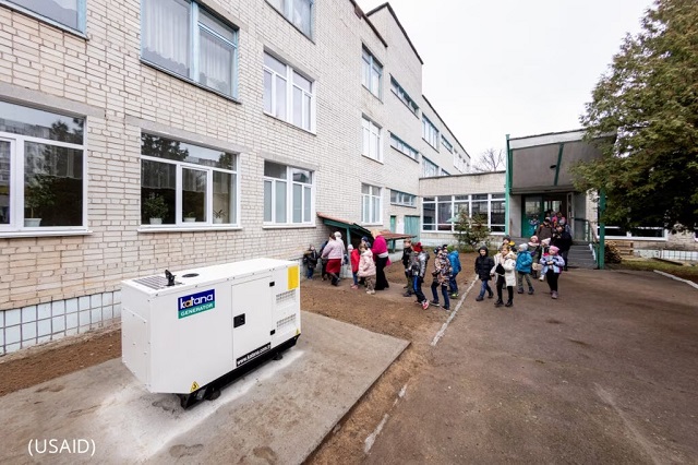 Children head into a school powered by a USAID-donated generator. (USAID)