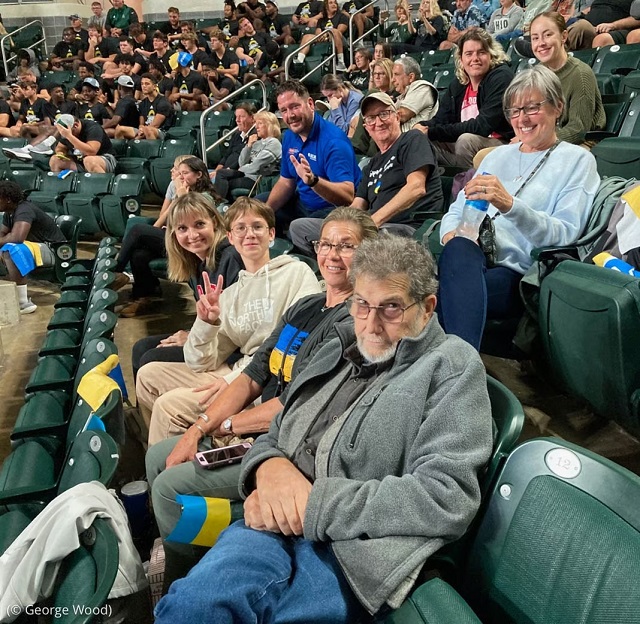 オハイオ州アセンズ郡の支援団体メンバーと共に、オハイオ大学でバレーボールの試合を観戦するウクライナ人家族。彼らは2022年8月に米国に渡ってきた (© George Wood)