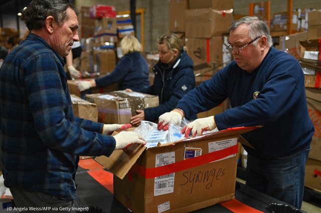 2022年3月8日、ニュージャージー州ポートリーディングにあるミーストアメリカ社の倉庫で、ウクライナ向け物資の仕分けを行う従業員とボランティア (© Angela Weiss/AFP via Getty Images)